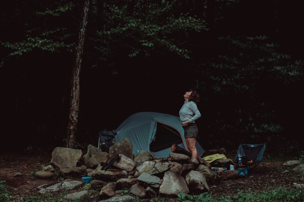 woman stretching near tent for her back health 